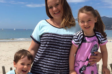 Mutter mit Kindern in bunter Jersey Kleidung am Meer