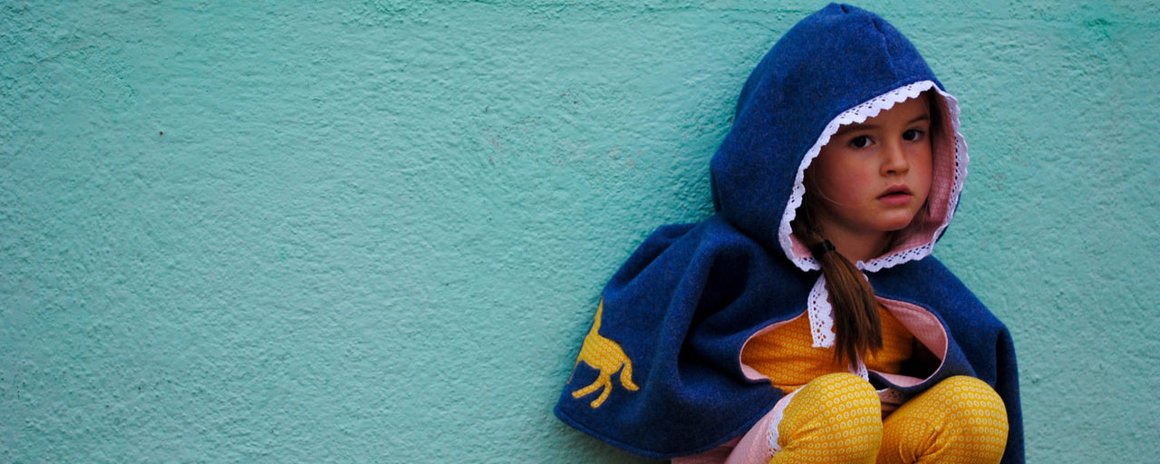 Mädchen in dunkelblauem Bio Fleece Umhang