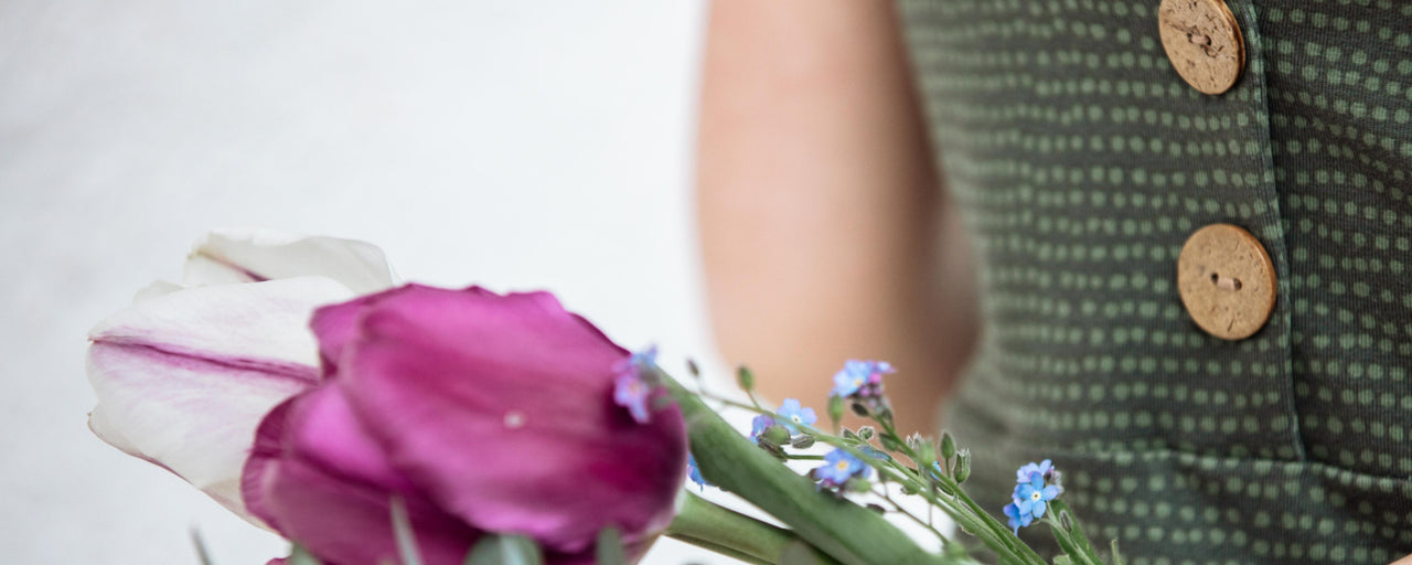 Mädchen in Kleidung aus fairtrade Biostoffen mit Blumen