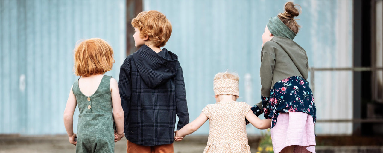 Vier Kinder in Kleidung aus fairtrade Biostoffen